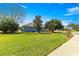 The backyard features a lush lawn and mature trees providing shade and privacy at 9230 Sw 66Th Loop, Ocala, FL 34481