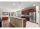 Open-concept kitchen with stainless steel appliances, dark cabinets, and bar seating area at 9230 Sw 66Th Loop, Ocala, FL 34481