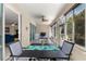 Screened lanai with dining table, seating area, and view into the Gathering room through sliding doors at 9230 Sw 66Th Loop, Ocala, FL 34481