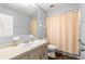 Bathroom featuring a neutral vanity, toilet, and shower-tub combination with a peach-colored shower curtain at 10954 Sw 83Rd Ct, Ocala, FL 34481