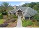 Stately home boasts a manicured lawn with mature landscaping and a grand entrance with stone accents at 10954 Sw 83Rd Ct, Ocala, FL 34481