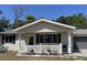 Charming single-story home with a covered front porch, a white picket fence and a well-manicured lawn at 10954 Sw 83Rd Ct, Ocala, FL 34481