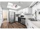 Bright kitchen featuring stainless steel appliances, clean white cabinets, and wood-look flooring for a modern feel at 10954 Sw 83Rd Ct, Ocala, FL 34481