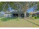 Spacious screened lanai overlooking the lush green yard, mature tree, and landscape, perfect for relaxing outdoors at 13968 Se 96Th Cir, Summerfield, FL 34491