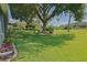 Expansive backyard featuring lush green lawn, mature trees, and manicured garden beds, creating a private retreat at 13968 Se 96Th Cir, Summerfield, FL 34491