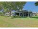 Spacious screened lanai overlooking the lush green yard, mature tree, and landscape, perfect for relaxing outdoors at 13968 Se 96Th Cir, Summerfield, FL 34491