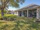 A beautiful screened-in porch and well-maintained lawn make the backyard a relaxing outdoor space at 13968 Se 96Th Cir, Summerfield, FL 34491