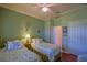 Bedroom boasts twin beds, a ceiling fan, and stylish decor, offering a comfortable retreat at 13968 Se 96Th Cir, Summerfield, FL 34491