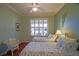 Bedroom featuring two twin beds, bright window, hardwood floors and cozy wicker chair at 13968 Se 96Th Cir, Summerfield, FL 34491