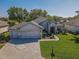 Aerial view of a well-maintained one story home with lush green lawn, and a brick paved driveway at 13968 Se 96Th Cir, Summerfield, FL 34491