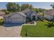 Aerial view of a well-maintained home with beautiful landscaping and a brick paved driveway at 13968 Se 96Th Cir, Summerfield, FL 34491