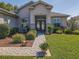 Close up of a home's front door entrance with decorative glass doors, landscaped beds, and a brick walkway at 13968 Se 96Th Cir, Summerfield, FL 34491