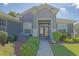 Welcoming front entrance with decorative glass doors, brick-paved walkway, and lush landscaping adding charm to the home at 13968 Se 96Th Cir, Summerfield, FL 34491