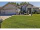 Charming one-story home with lush green lawn, beautiful landscaping, and a brick paved driveway at 13968 Se 96Th Cir, Summerfield, FL 34491