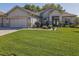 Charming one-story home with lush green lawn, beautiful landscaping, and a brick paved driveway at 13968 Se 96Th Cir, Summerfield, FL 34491