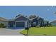 Charming single Gathering home featuring a lush green lawn, professional landscaping, and a convenient three-car garage at 13968 Se 96Th Cir, Summerfield, FL 34491
