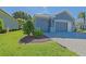 Spacious two-car garage with attractive curb appeal and brick-paved driveway, complemented by well-manicured landscaping at 13968 Se 96Th Cir, Summerfield, FL 34491