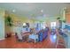 Spacious living room with hardwood floors, open layout, and a view of the breakfast nook at 13968 Se 96Th Cir, Summerfield, FL 34491