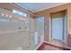 A bathroom featuring a glass shower with marble tiling, a small stained glass window, and double shower heads at 13968 Se 96Th Cir, Summerfield, FL 34491