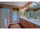 This bathroom features double sinks, lots of counter space, a large mirror, tile flooring and a glass enclosed shower at 13968 Se 96Th Cir, Summerfield, FL 34491