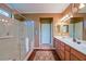 A spacious bathroom with a large glass shower, tile flooring and a double sink vanity at 13968 Se 96Th Cir, Summerfield, FL 34491
