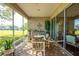 Inviting screened patio features brick floors, comfortable seating, and views of the lush surrounding landscape at 13968 Se 96Th Cir, Summerfield, FL 34491