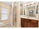 The bathroom features a glass door shower, tan tile, and dark wood cabinets with a granite countertop at 12240 Se 172Nd Ln, Summerfield, FL 34491