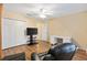 Bonus room features hardwood floors, a ceiling fan, a TV, a work desk, and a cozy black chair at 12240 Se 172Nd Ln, Summerfield, FL 34491