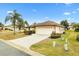 Well maintained lawn, shrubs and a palm tree compliment this single story home with a two car garage at 12240 Se 172Nd Ln, Summerfield, FL 34491