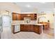 Spacious kitchen featuring tiled floors, wooden cabinets, modern appliances, and a view to the dining area at 12240 Se 172Nd Ln, Summerfield, FL 34491