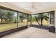 Enclosed lanai featuring a ceiling fan, beautiful views of the landscaped yard, and plenty of natural light at 12240 Se 172Nd Ln, Summerfield, FL 34491