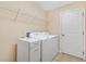 Laundry room featuring white appliances and cabinets, neutral colored walls, and light tile flooring at 12240 Se 172Nd Ln, Summerfield, FL 34491