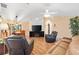 Cozy living room with high ceilings, ceiling fan, hardwood flooring, comfortable seating, and view to dining room at 12240 Se 172Nd Ln, Summerfield, FL 34491