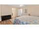 Spacious main bedroom with a floral comforter and hardwood flooring with a black dresser on the side at 12240 Se 172Nd Ln, Summerfield, FL 34491