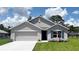 Charming single-story home featuring a two-car garage, manicured lawn, and elegant blue shutters at 16805 Sw 50Th Cir, Ocala, FL 34473