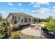 Back exterior view of the home with brick patio, lush landscaping, and shutters on the windows at 2380 Nw 55Th Avenue Rd, Ocala, FL 34482