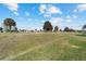 The large backyard has a beautiful view of a golf course and a blue, partly cloudy sky at 2380 Nw 55Th Avenue Rd, Ocala, FL 34482