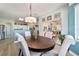 Open dining room featuring an elegant chandelier, sliders to the lanai and a partial view of the kitchen at 2380 Nw 55Th Avenue Rd, Ocala, FL 34482