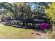 Brick home with covered front porch, complemented by a well-manicured lawn and large trees at 2570 Se Highway 42, Summerfield, FL 34491