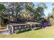 Charming brick home with a covered porch, green lawn, and mature landscaping at 2570 Se Highway 42, Summerfield, FL 34491