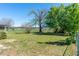 Wide view of the backyard showing the trees, the lawn, and the fenced-in area beyond at 3275 Nw 44Th Ct, Ocala, FL 34482