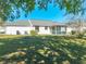Spacious backyard featuring a well-maintained lawn, screened-in porch with chairs, and lush greenery at 3275 Nw 44Th Ct, Ocala, FL 34482