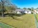 Large fenced backyard with screened in porch and mature trees and a lush green lawn at 3275 Nw 44Th Ct, Ocala, FL 34482