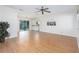 Open-concept living room with wood flooring, ceiling fan, and sliding glass doors to patio at 3275 Nw 44Th Ct, Ocala, FL 34482