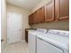 Functional laundry room features a side-by-side washer and dryer, and upper cabinets at 3935 Nw 46Th Ter, Ocala, FL 34482