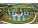 Aerial view of a stunning resort style zero entry pool, tennis courts, and lush landscaping at 3935 Nw 46Th Ter, Ocala, FL 34482