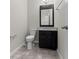 Bathroom featuring dark vanity with mirror, tiled floor, and toilet at 5048 Sw 57Th Pl, Ocala, FL 34474