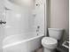 Bright bathroom featuring a white tiled shower-tub and toilet at 5048 Sw 57Th Pl, Ocala, FL 34474