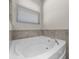 Bright bathroom showcasing a white bathtub and a window providing natural light at 5048 Sw 57Th Pl, Ocala, FL 34474