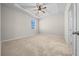 Bright bedroom with a ceiling fan, tray ceiling, and neutral carpet at 5048 Sw 57Th Pl, Ocala, FL 34474